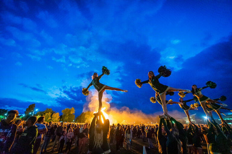 Photo of Homecoming bonfire with spirit squad and event attendees.